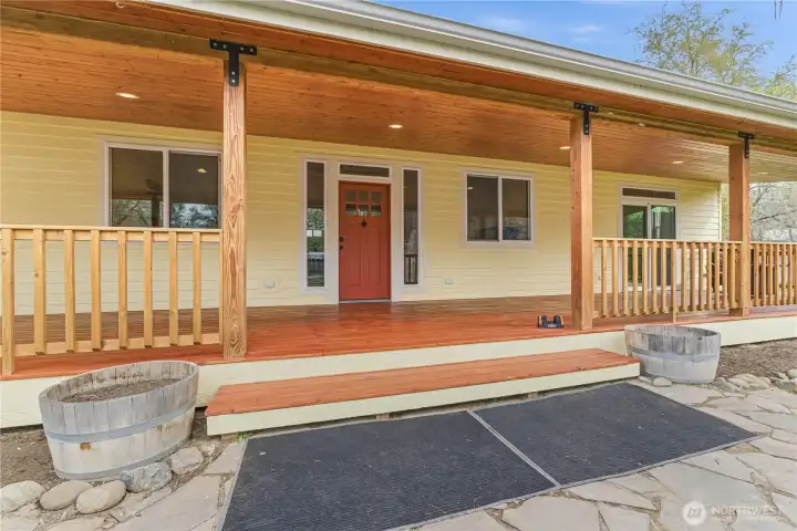Front entrance with a slate patio & huge 600' fully covered front porch with soffit lighting & gutters has lots of room for a hot tub, porch swing, & outdoor dining to enjoy sunsets.