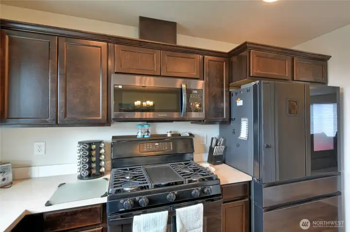 Stove, refrigerator to the right.