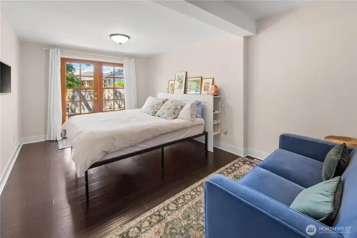 Spacious main-floor bedroom boasts an impressive walk-in closet and French doors opening to the private backyard retreat.