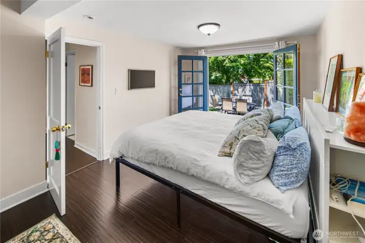 Spacious main-floor bedroom boasts an impressive walk-in closet and French doors opening to the private backyard retreat.