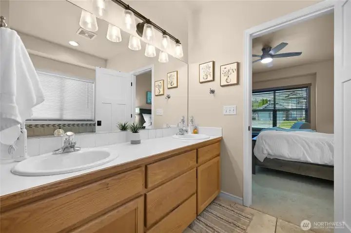 Primary bathroom with double sinks, jetted bathtub and custom closet.