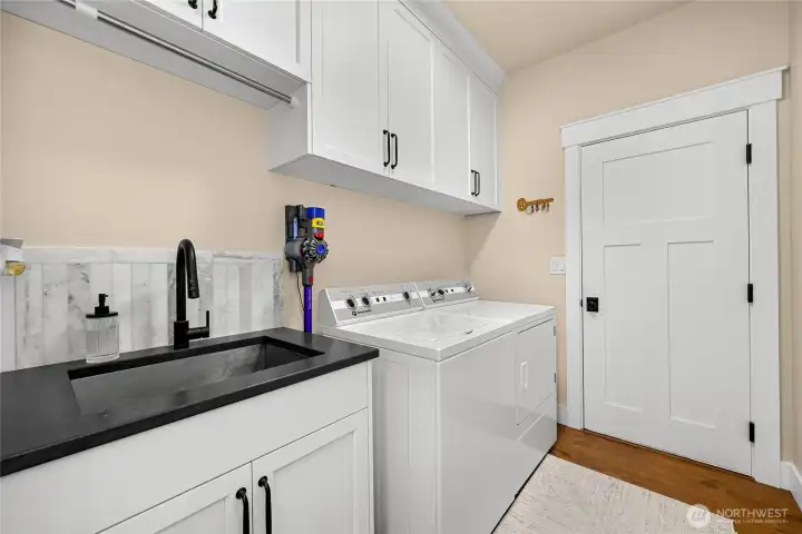 Full laundry room with more storage, utility sink and entry to garage.