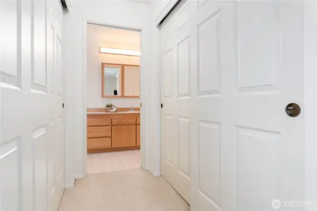 Hall of closets leading from bedroom to main full bathroom