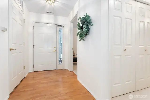 Looking towards the front door, hall to guest .75 bathroom and laundry behind the according doors as well as extra storage on the other side of the hall.