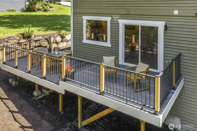 Expansive new Trex deck with custom modern railing overlooks a large backyard.