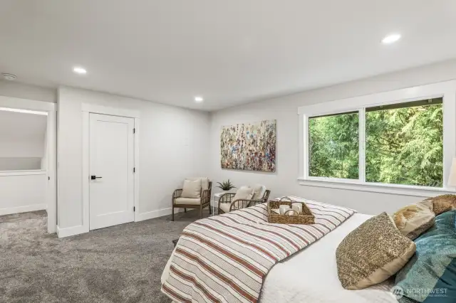This light-filled primary suite overlooks the lush greenbelt.