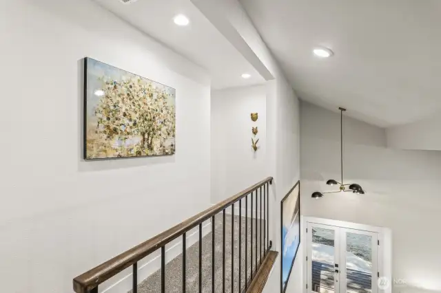 An open hallway leads to two additional bedrooms, each thoughtfully updated with fresh paint, lush carpeting, and stylish finishes.