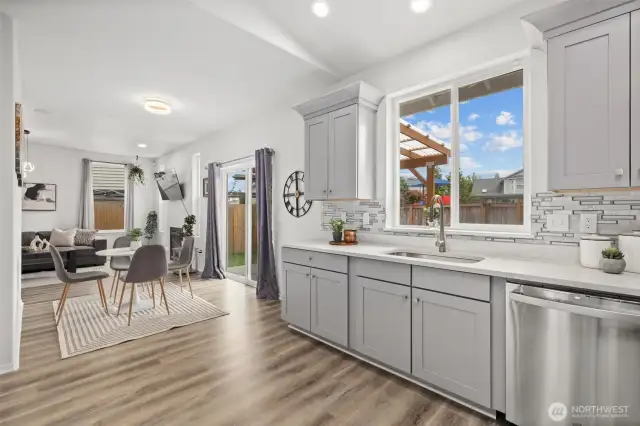 View from Kitchen to Dining Nook & Family Room with Gas Fireplace. TV Mount stays.