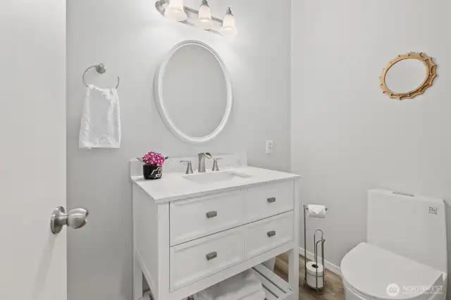 Main Level Half Bath with new floor, new vanity, new toilet.