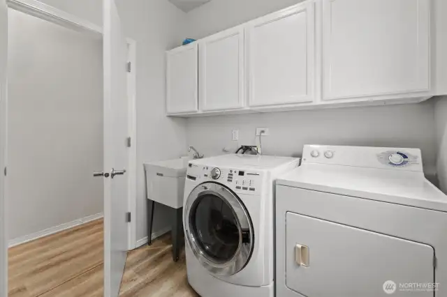 Main level utility room. Washer and Dryer stay. There is a large hanging shelf on the opposite wall perfect for coats.