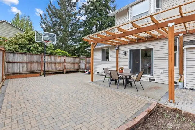 Covered Pergola to enjoy your backyard year round with permanently installed Basketball Hoop and Paver Backyard. Easy maintenance with a garden space.