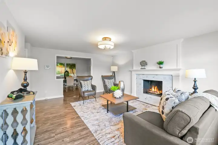 Inside, the living room greets you with natural light and a striking fireplace as the focal point. This space is perfect for gathering and relaxation.