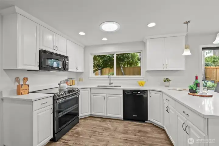 An additional angle of the kitchen showcases the efficient layout, complete with sleek appliances, abundant storage, and a spacious workspace for cooking.