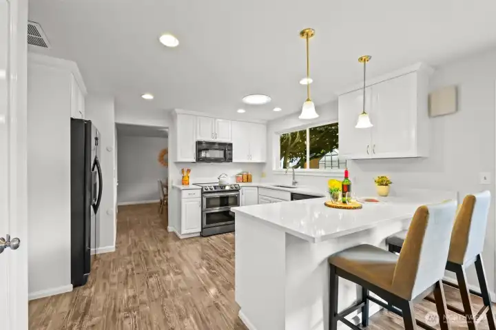 A breakfast bar offers casual seating and connects the kitchen with an additional dining area. This space is ideal for enjoying morning coffee or quick meals.