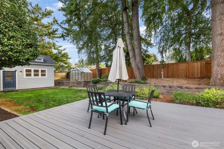 A large composite deck offers ample room for outdoor dining and entertaining, overlooking the landscaped yard and garden spaces.