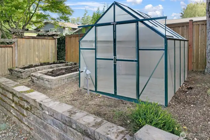 A greenhouse and raised beds provide excellent opportunities for gardening and year-round growing.