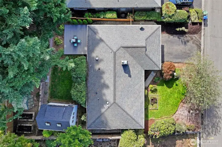 Aerial view of the property showcases the home’s layout, detached flex space, and outdoor amenities.