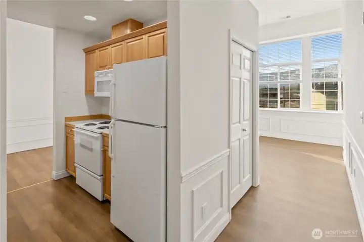 Kitchen to left, coat closet ahead and living room with high windows for great lighting ahead.