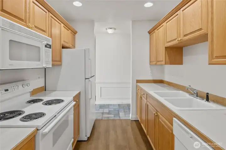 Looking back at the entry way past sparkling white appliances.
