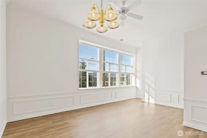 Dining area looking back towards high living room windows, Notice wainscoting panels throughout.