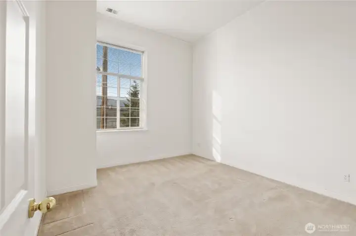 Bedroom with high windows and blinds.