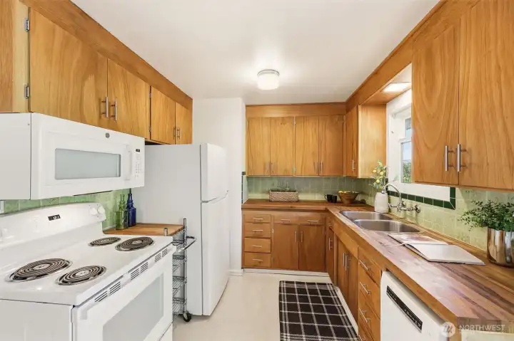 Good amount of storage in this sweet kitchen!  Vintage wall tiles are in great condition.  A Boesch dishwasher was added in 2023 and other appliances are newer.  Flooring is warm, quiet and durable cork!