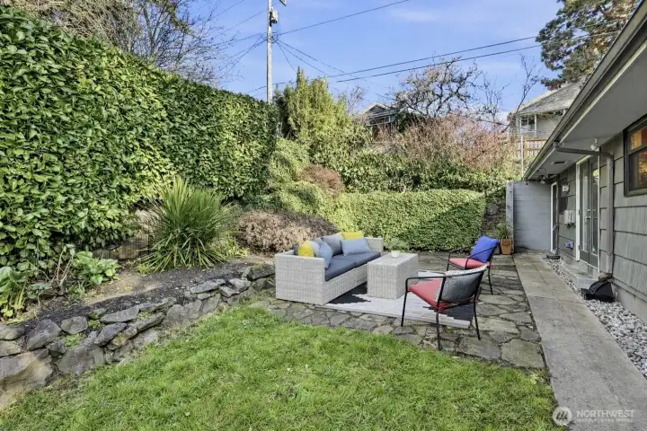 The private backyard is flat with tiered landscaped beds on the north and east sides.