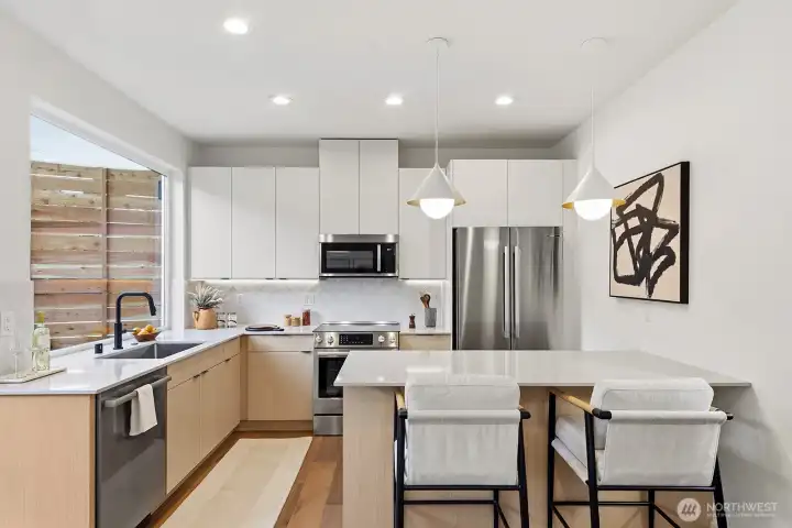 Well-appointed kitchen with SS appliances, under-cabinet lighting, and custom cabinetry.