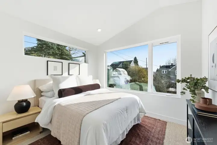 The primary suite has vaulted ceilings, large windows that provide great afternoon light, a walk-in closet, and spa-like bathroom.