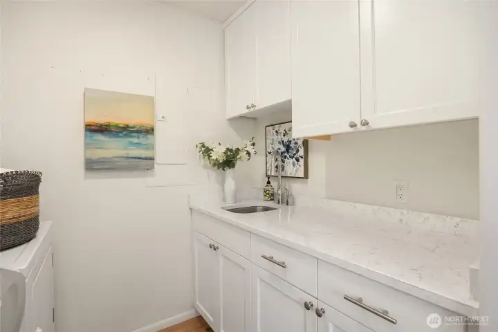 A full walk-in laundry & storage room is located near the kitchen.