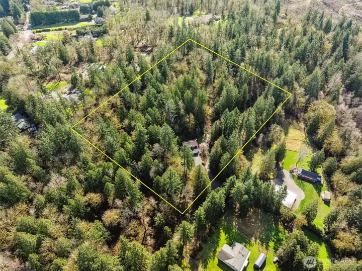 A bird’s-eye view showcases the home’s expansive outdoor space and acreage.