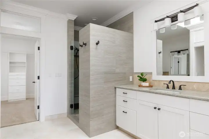 Primary suite bath with separate vanities, walk in shower and radiant heat in floor