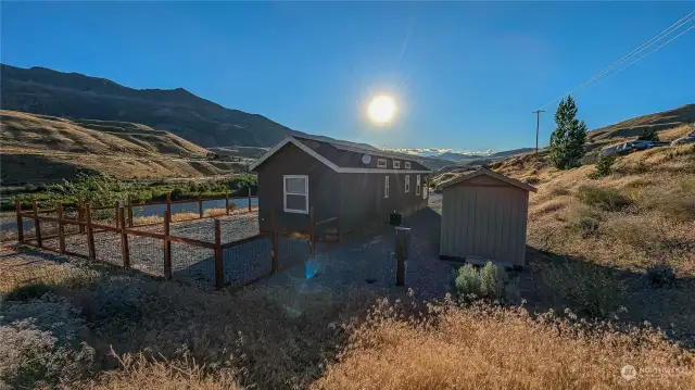 There is a shed and a fenced yard. Looking West from NE area of property.