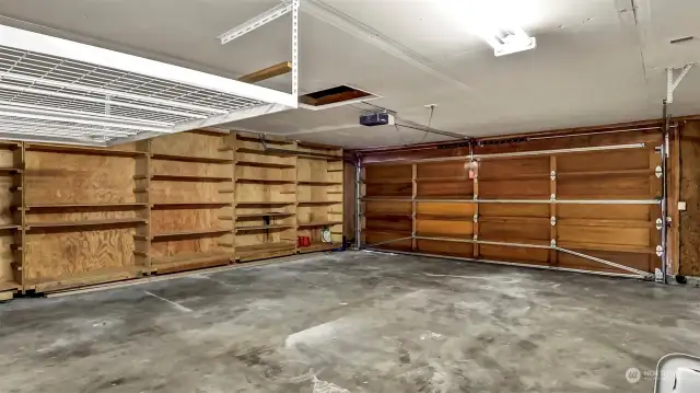 Large two car garage with storage shelves.