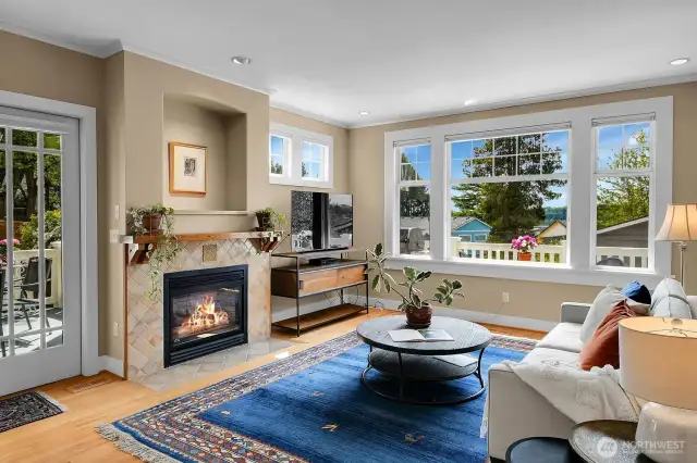 Looking into the family room from the kitchen counter. Big blue sky, and mature trees.