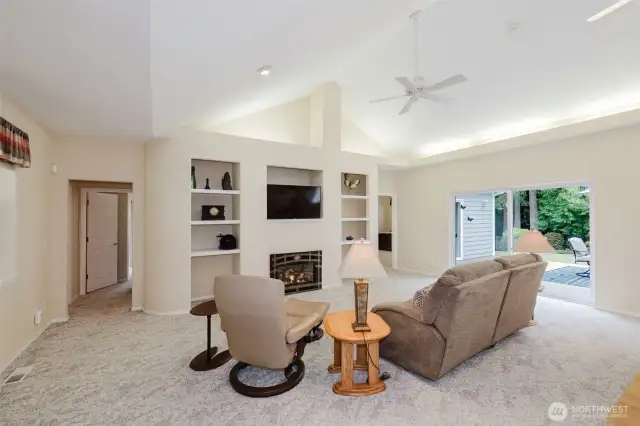 Gas fireplace sets the ambiance for the large living room.  Slider leads out to the large back patio.  Hallways on either side of the fireplace lead to the bedrooms and guest bathroom.