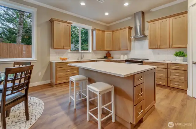 Large kitchen area with custom designed karamel stain wood cabinets plus island and stainless finish appliances make this area a chef's dream