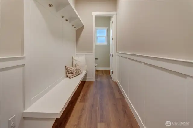 Custom white-painted seating and shelving, just off the garage area, plus s convenient half bath provide the perfect and inviting area as you enter this classic new home