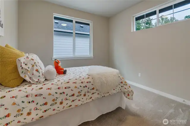 Each of the bedrooms included in this new home design are spacious, incorporate the use of well-placed and energy-efficient custom vinyl clad windows without limiting the use of wall areas for furniture placement.