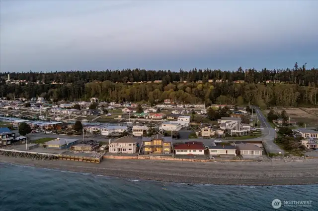 An aerial perspective showcases the sleek, modern architecture of this custom-built Whidbey Island home. Perfectly positioned on 60 feet of low-bank saltwater waterfront, the west-facing design maximizes natural light and frames sweeping views of Puget Sound sunsets.