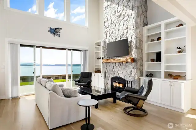 From this perspective, the room’s centerpiece comes to life: a floor-to-ceiling stone fireplace framed by custom built-ins that combine functionality with architectural elegance. The design creates a cozy gathering space while highlighting the home’s attention to detail and craftsmanship