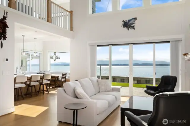 The heart of the home, this stunning great room showcases soaring ceilings and an entire wall of view windows. Flooded with natural light, the space seamlessly blends indoors with the surrounding beauty—Puget Sound, Olympic Mountains, and unforgettable sunsets become part of your everyday living.the sparkling waters of Puget Sound & Admiralty Inlet