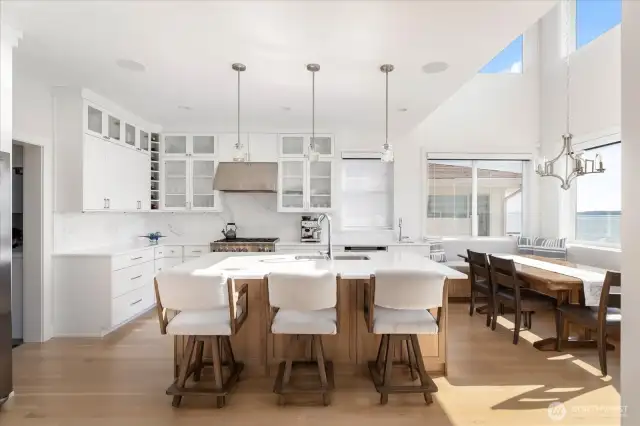 This stunning waterside kitchen is built for both style and performance. A spacious island anchors the room, while commercial-style, chef-approved appliances make meal preparation effortless. Expansive windows frame sparkling saltwater views, turning every culinary experience into an inspiring waterfront event