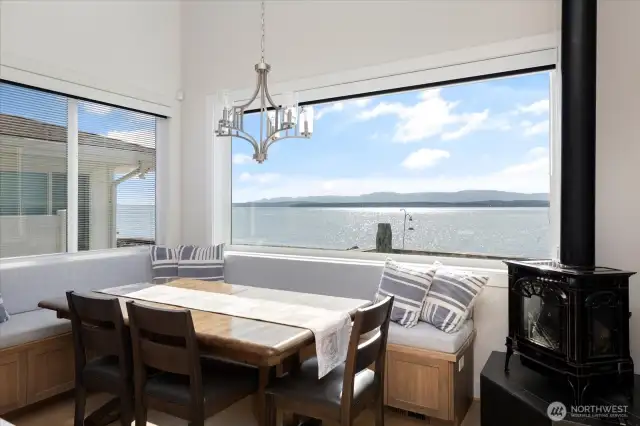 This thoughtfully designed dining area combines comfort and functionality. The built-in bench with storage and inviting fireplace creates a cozy atmosphere, while French doors open directly to the waterside patio and dining area, allowing meals to flow naturally between indoor elegance and outdoor waterfront enjoyment.