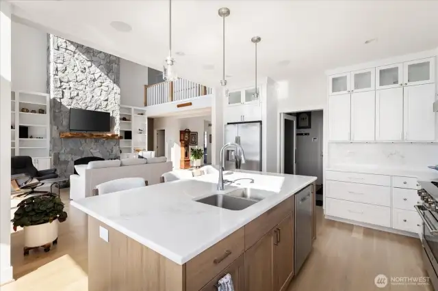 This kitchen combines elegance and practicality with custom cabinetry, gleaming stainless steel appliances, and sleek quartz countertops. Extra-high cabinets with built-in lighting provide ample storage while showcasing thoughtful design, making this space as visually striking as it is functional.
