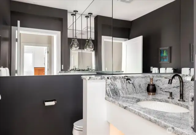 This chic powder room exudes style and sophistication. Thoughtfully designed with high-end finishes, beauty-inspired details, and integrated lighting, it offers a modern, glamorous touch that makes every visit feel luxurious.