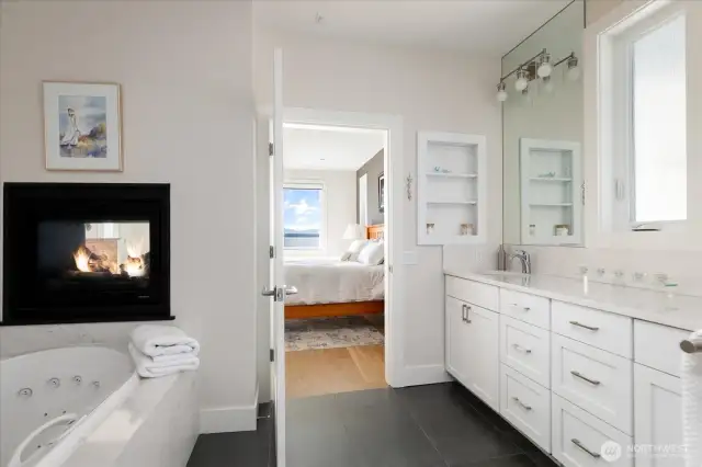 This exquisite 5-piece primary bath offers a spa-inspired retreat with double sinks, sleek quartz countertops, a relaxing soaking tub, and a separate glass-enclosed shower. Directly adjacent, a custom walk-in closet with thoughtfully designed built-ins provides ample storage and organization, seamlessly combining luxury, function, and style