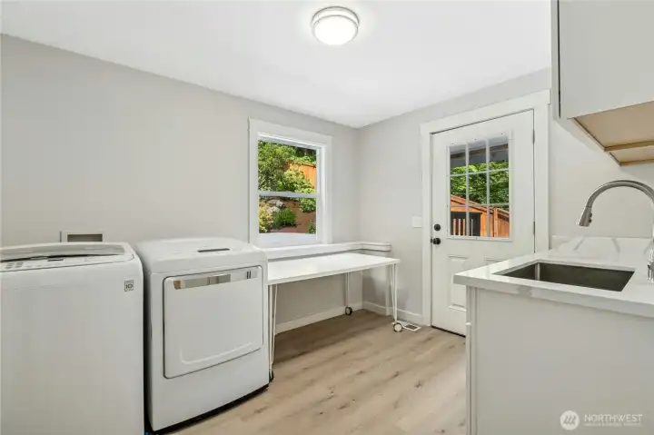 Huge laundry room with door to backyard, sink & folding table