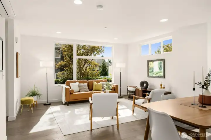 Sunny living room overlooks lush landscaping