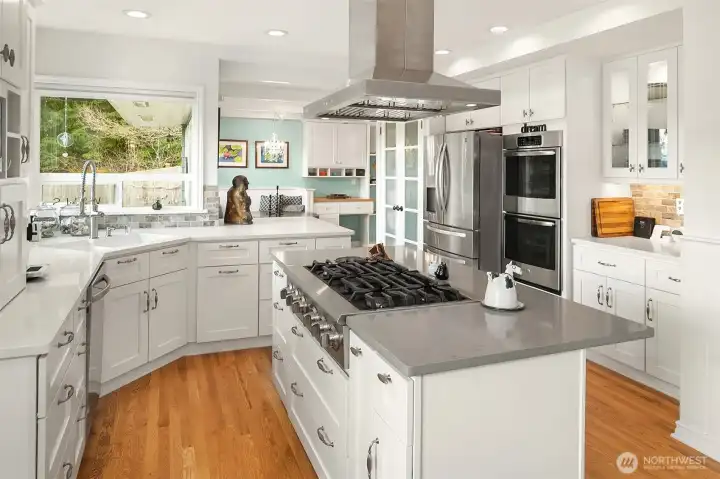 The bright, modern kitchen features six-burner gas cooking and a double oven.